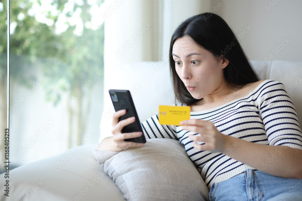 Surprised asian woman buying online at home Surprised asian woman buying online at home