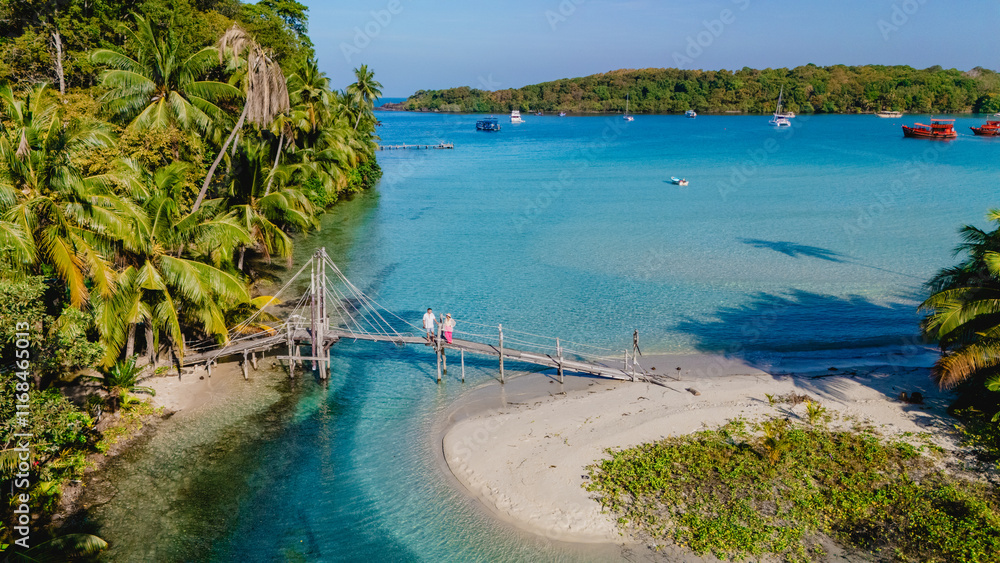 Serene day at Koh Kood's tropical shoreline with wooden bridge connecting pristine waters