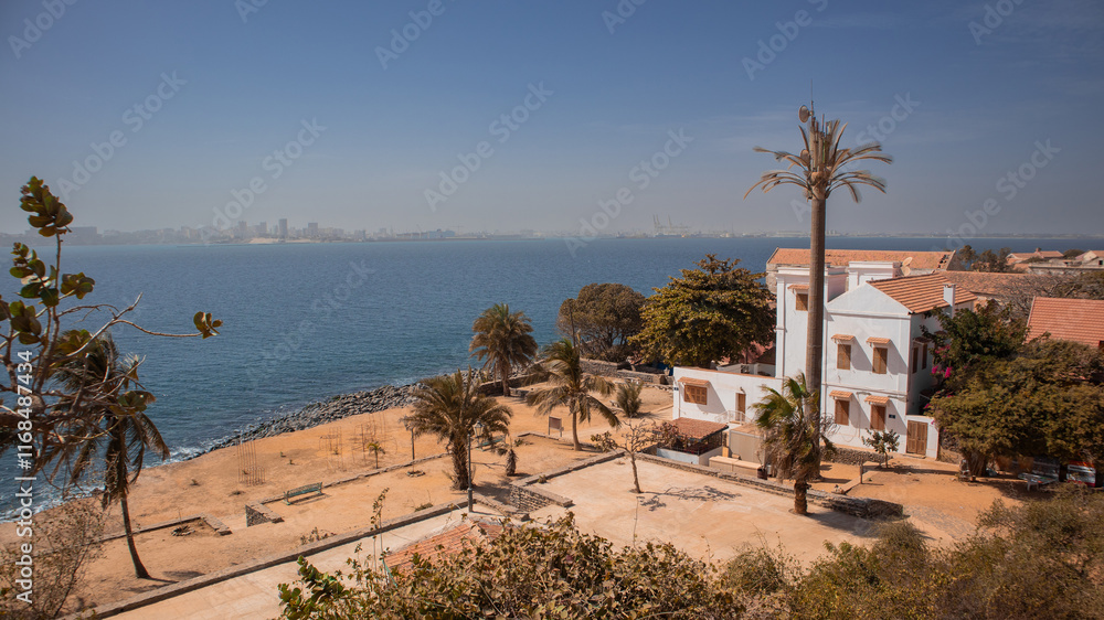 Slave trade houses on the famous island of Goree in the atlantic ocean just outside of Dakar city. Dakar skyline is seen in the background, great panoramic photo of a sad island.