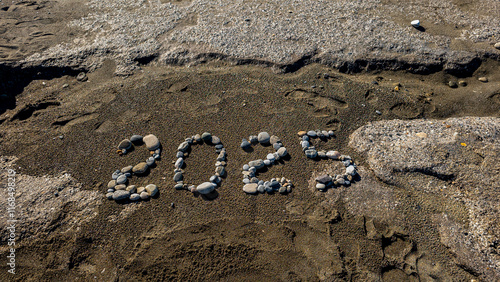 Obraz na płótnie 2025 Written with Stones on Sandy Beach by the Sea w salonie