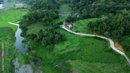 San Miguel, Catanduanes, Philippines - A Picturesque Scene of Rural Houses Nestled by the River, Enveloped in Vibrant Greenery - Aerial Drone Shot photo