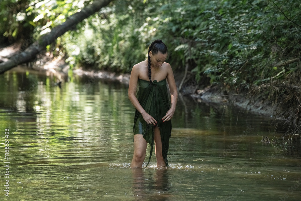 Beautiful young girl posing in a fast forest river in summer.