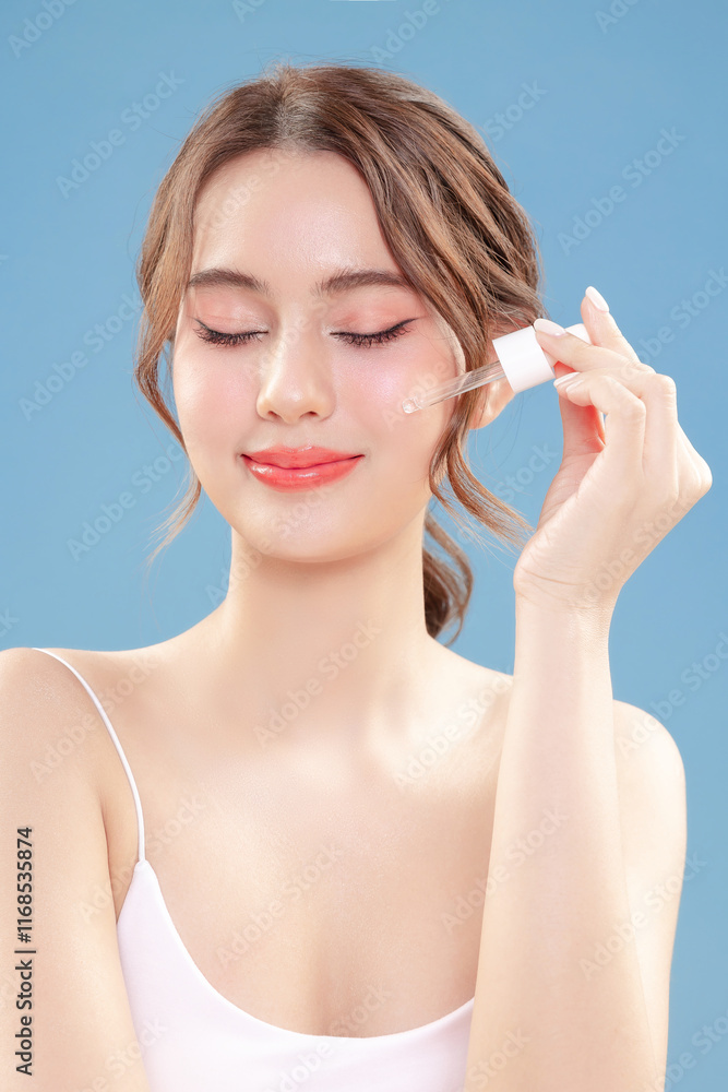 Young Asian beauty woman pull back hair with Koreans makeup style on face and perfect clean skin apply serum on isolated blue background. Facial treatment, Cosmetology, plastic surgery. Young Asian beauty woman pull back hair with Koreans makeup style on face and perfect clean skin apply serum on isolated blue background. Facial treatment, Cosmetology, plastic surgery.