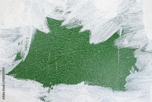 old concrete wall covered with textured plaster and painted with green paint. splashes of white paint and cracks. background for design photo