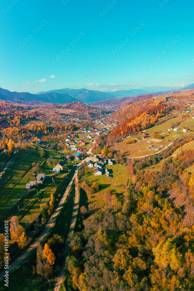 Panoramic view from above of colorful mountain slopes on a sunny autumn day. Beautiful landscape. Carpathian mountains, Kolochava, Ukraine. Vertical photo
