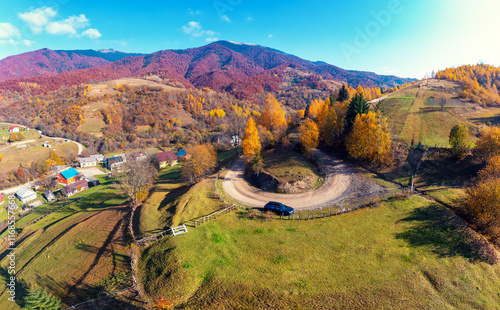 Panoramic view from above of colorful slopes of mountains on a sunny day in autumn. Beautiful landscape. Carpathian mountains, view from Prislop pass, Ukraine photo