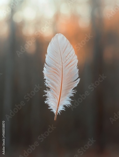 Delicate white feather gently floating against a serene natural backdrop in s...