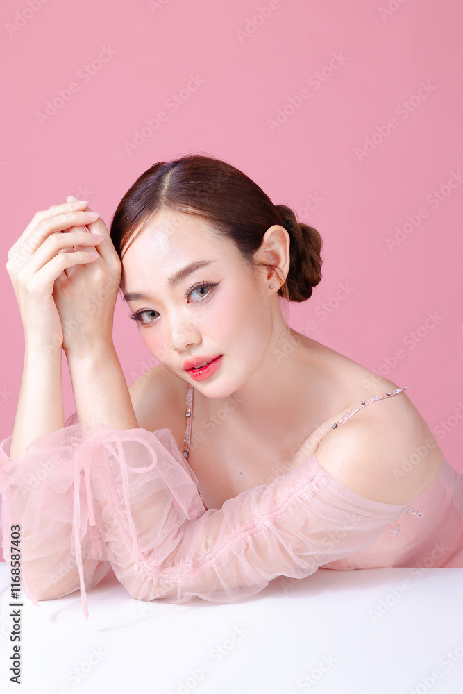 Beautiful young Asian woman model bun hair with natural makeup on face clean fresh skin on isolated pink background. Cute girl portrait, Facial treatment, Valentine concept. Beautiful young Asian woman model bun hair with natural makeup on face clean fresh skin on isolated pink background. Cute girl portrait, Facial treatment, Valentine concept.