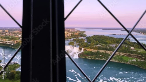 Scenic walk along the circular Skylon Tower, overlooking a vibrant Canadian cityscape at sunset with lush greenery and urban highlight, Canada photo