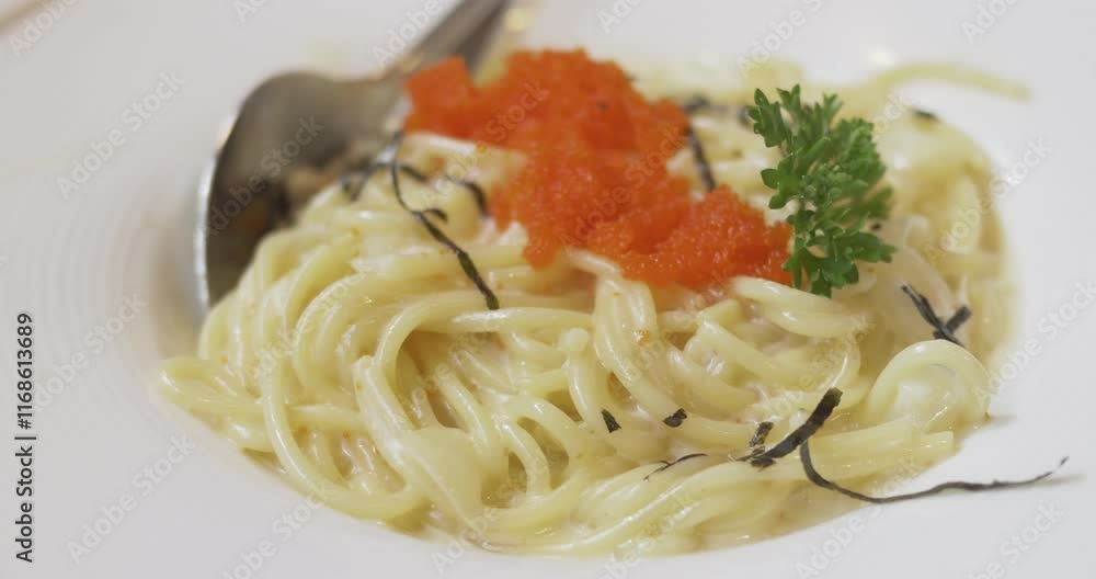 Close-up shot of creamy seafood spaghetti and its shrimp eggs toppings, served on a platter. Close-up shot of creamy seafood spaghetti and its shrimp eggs toppings, served on a platter.
