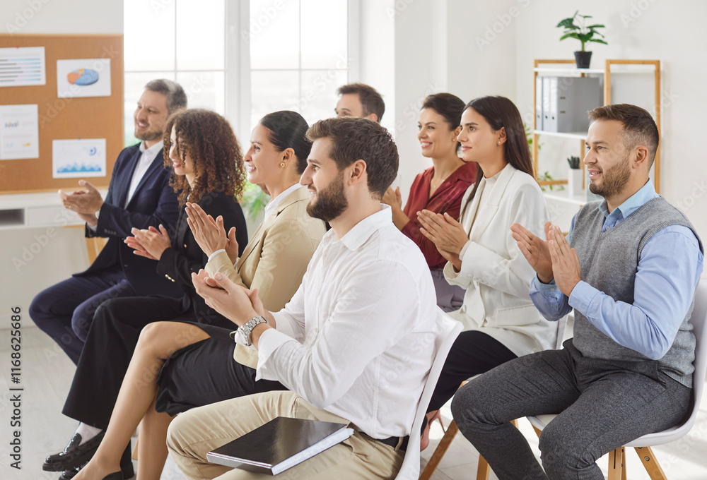 Group of happy joyful business people applauding to speaker sitting on chairs in a meeting room. Successful coworkers and company employees clapping a colleague on business training or conference. Group of happy joyful business people applauding to speaker sitting on chairs in a meeting room. Successful coworkers and company employees clapping a colleague on business training or conference.