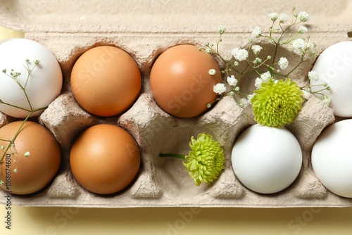 Chicken eggs in a cardboard package with flowers photo