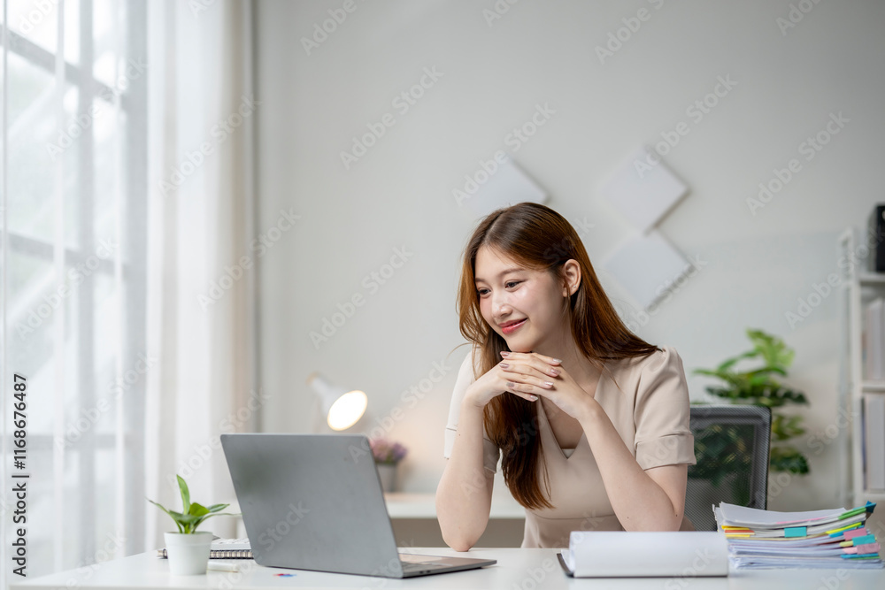 A woman is sitting at a desk with a laptop in front of her A woman is sitting at a desk with a laptop in front of her