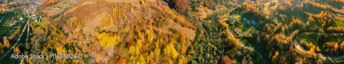 Panoramic view from above of colorful slopes of mountains on a sunny day in autumn. Beautiful landscape. Carpathian mountains, Kolochava, Ukraine. Horizontal banner photo