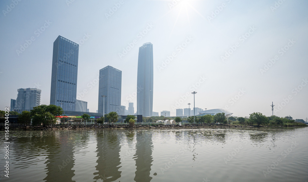 Modern Urban Skyline Reflected in Calm Waters Under Bright Sunlight Modern Urban Skyline Reflected in Calm Waters Under Bright Sunlight