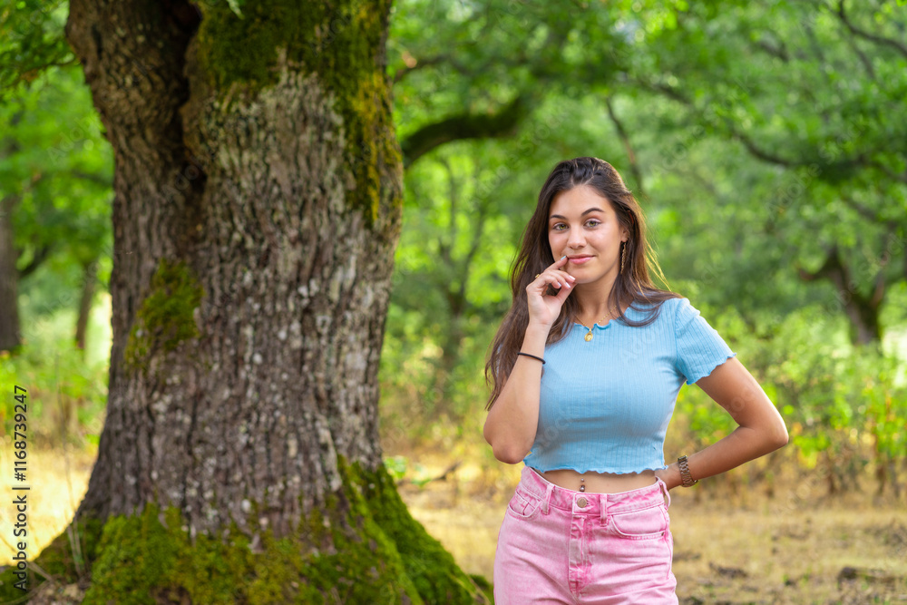 Young woman posing in the forest with hand on chin Young woman posing in the forest with hand on chin