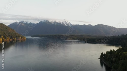 A stunning 4K aerial drone video of Lake Cushman and the surrounding mountains in Washington. The serene scene captures snow-capped peaks and forest reflections on the lake, perfect for nature lovers photo