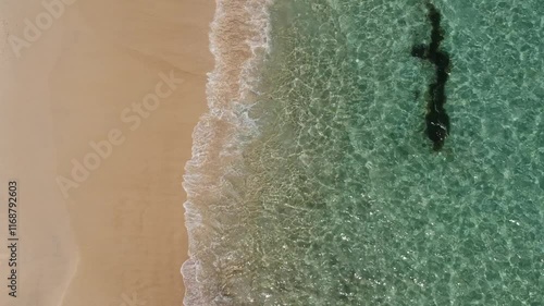 Wellen an einem Strand in Australien mit türkisblauem Wasser aus der Vogelperspektive