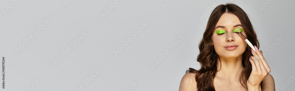 Attractive young woman showcases vibrant green eyeshadow and bold makeup in a studio, banner