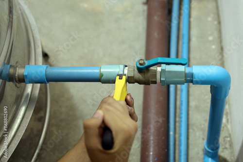 Plumber using a wrench to repair a water pipe. Concept of water pump maintenance fix water plumbing leaks drop or house bathroom service or cleaning clogged pipes is dirty or rusty. photo