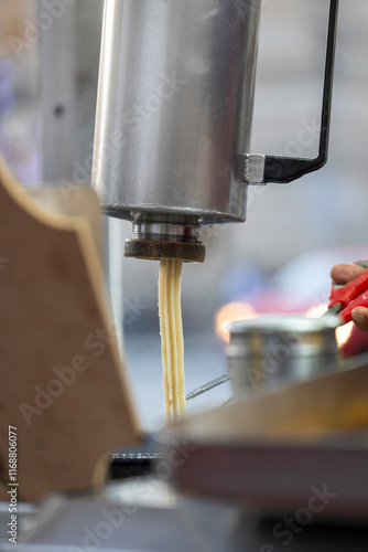 A vibrant display of freshly made churros in a metal tray, showcasing their crispy texture and appealing golden color, perfect for lovers of delicious snacks. photo