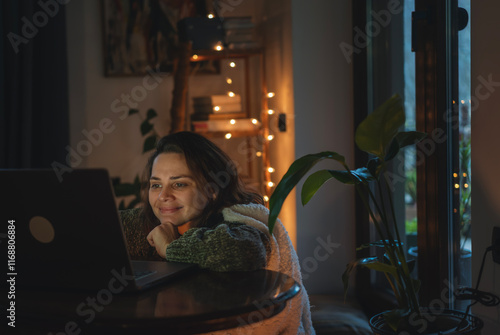 Happy freelancer female working using laptop at home in evening