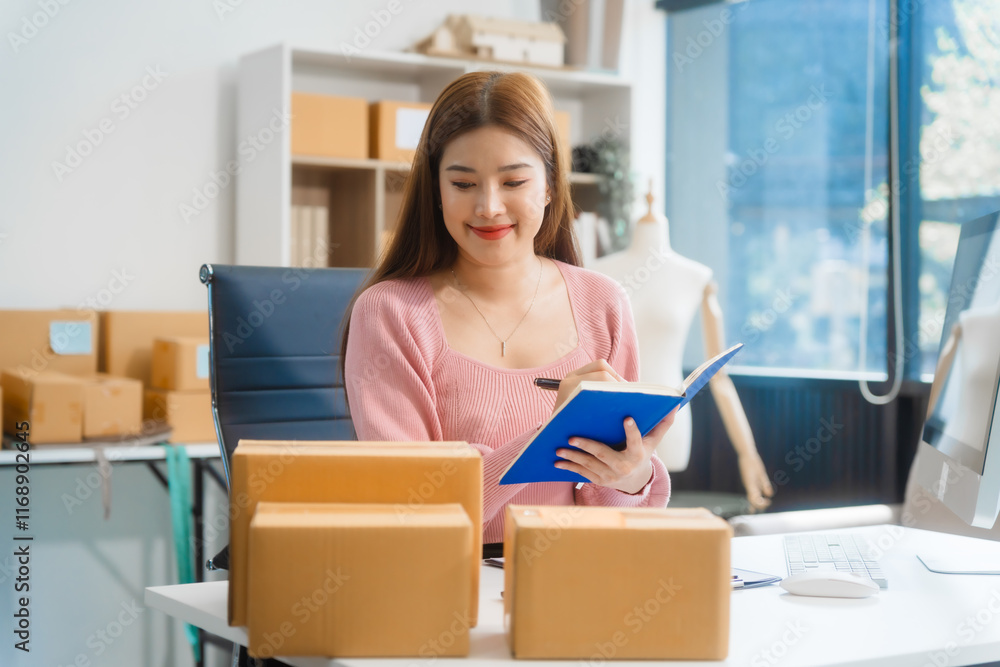 An Asian young woman sits in a room, working on a computer and making calls or video calls, managing her small business and online sales, surrounded by cardboard boxes ready for shipping. An Asian young woman sits in a room, working on a computer and making calls or video calls, managing her small business and online sales, surrounded by cardboard boxes ready for shipping.