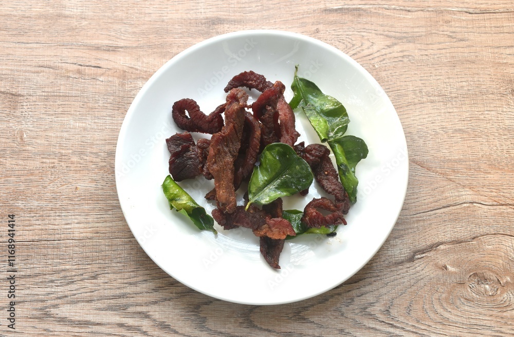 fried crispy salty fermenting beef meat with lemon leaf and chili on plate fried crispy salty fermenting beef meat with lemon leaf and chili on plate