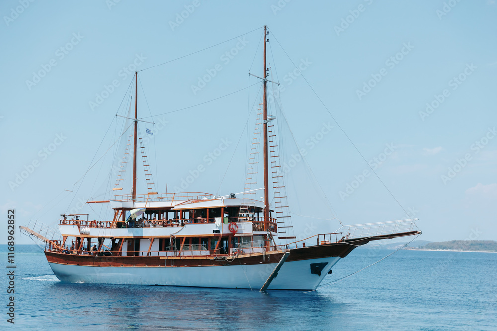 Large boat is sailing in the ocean with a blue sky in the background Large boat is sailing in the ocean with a blue sky in the background
