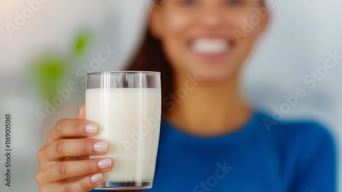 Smiling woman holding glass of milk, representing healthy lifestyle, nutrition, and freshness in modern dietary habits and wellness-focused themes for advertising concepts. photo