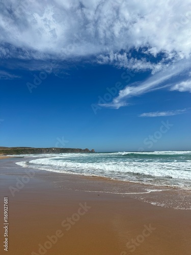 Australian beach in the morning as the waves roll onto the sandy shore