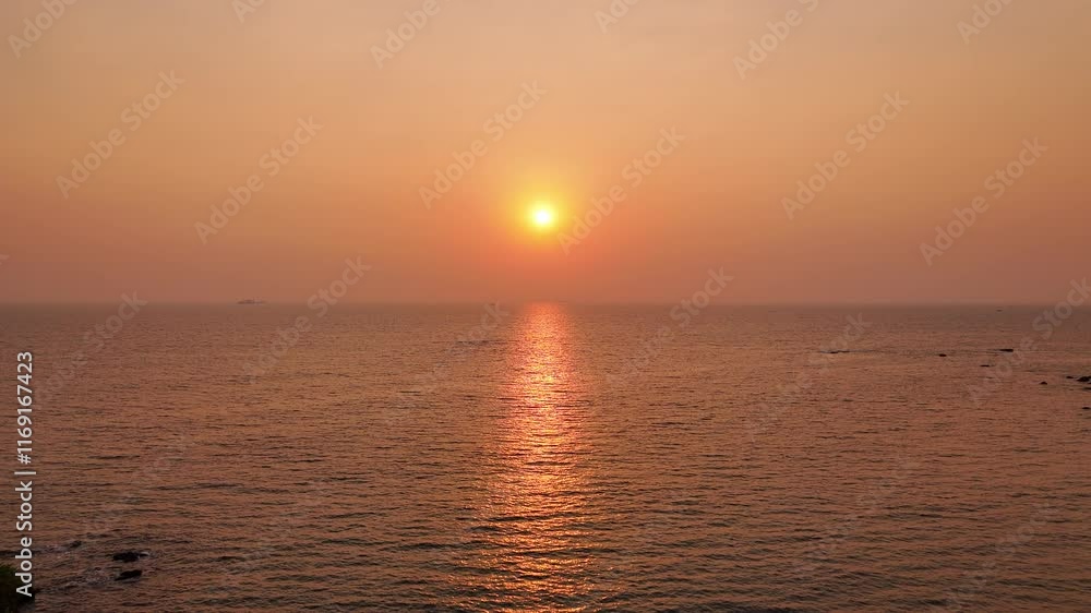 Drone view of stunning sunset over the ocean with orange sky Drone view of stunning sunset over the ocean with orange sky