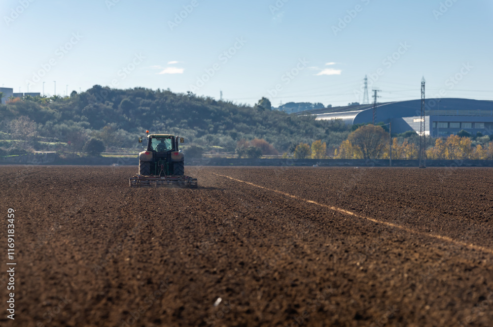 Fototapeta premium Backlit: Agricultural Tractor in Motion, Plowing the Field.