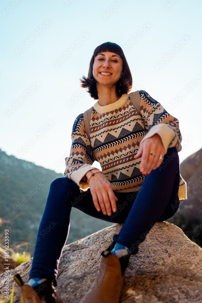 Naklejka premium Portrait of happy female tourist in mountains. girl smiles. trekking and hiking. girl with backpack.