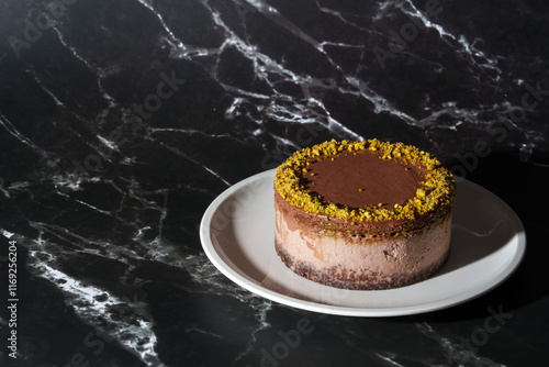 Canvas Print Dubai chocolate cheesecake with pistachio paste and kataifi dough filling covered in chocolate ganache on white plate