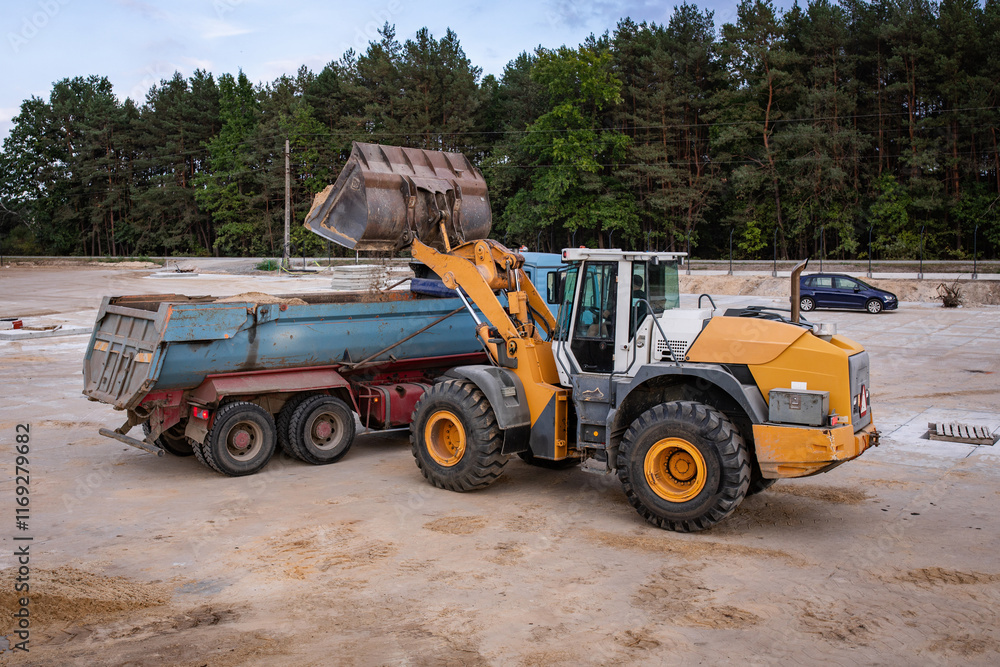 WWheel front loader at a construction site in a quarry. Powerful modern equipment for earthworks. Construction site. Heavy wheel loader at work. WWheel front loader at a construction site in a quarry. Powerful modern equipment for earthworks. Construction site. Heavy wheel loader at work.