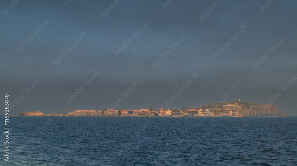 Far panorama view of ilee de goree, slave island in the bay of Dakar, export point for slaves from africa to the world. Evening light with sun.