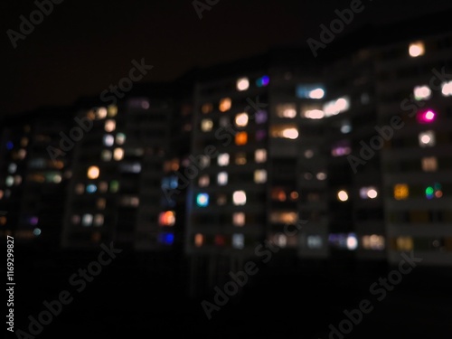 Wallpaper Mural Night urban landscape. Bright light of different colors from the windows of a multi-storey building, blurred. The lights are on in the windows of the houses at night Torontodigital.ca