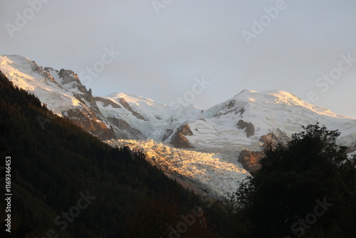 A breathtaking mountain peak covered in snow, set in a cold, clear winter landscape. The scene conveys a serene and majestic atmosphere, perfect for themes related to nature, travel, or adventure. photo