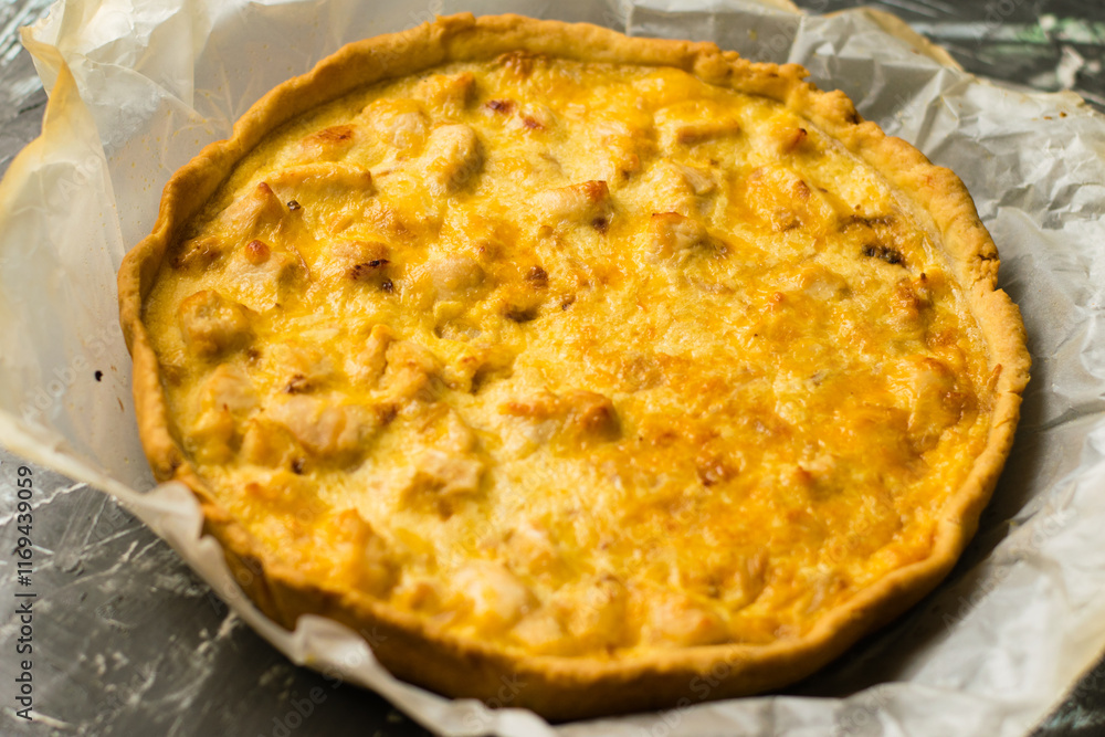 Delicious French quiche pie with chicken and cheese. Baking process, pie cooling on baking parchment Delicious French quiche pie with chicken and cheese. Baking process, pie cooling on baking parchment