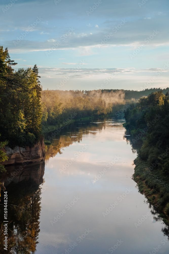 Fototapeta premium scenic view of the river where the background is forests over forests fog and the evening sun shines