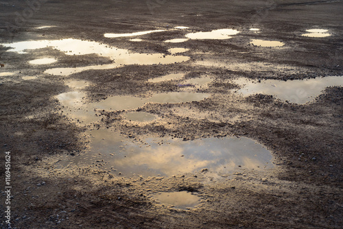 Cielo reflejado en charcos en un descampado