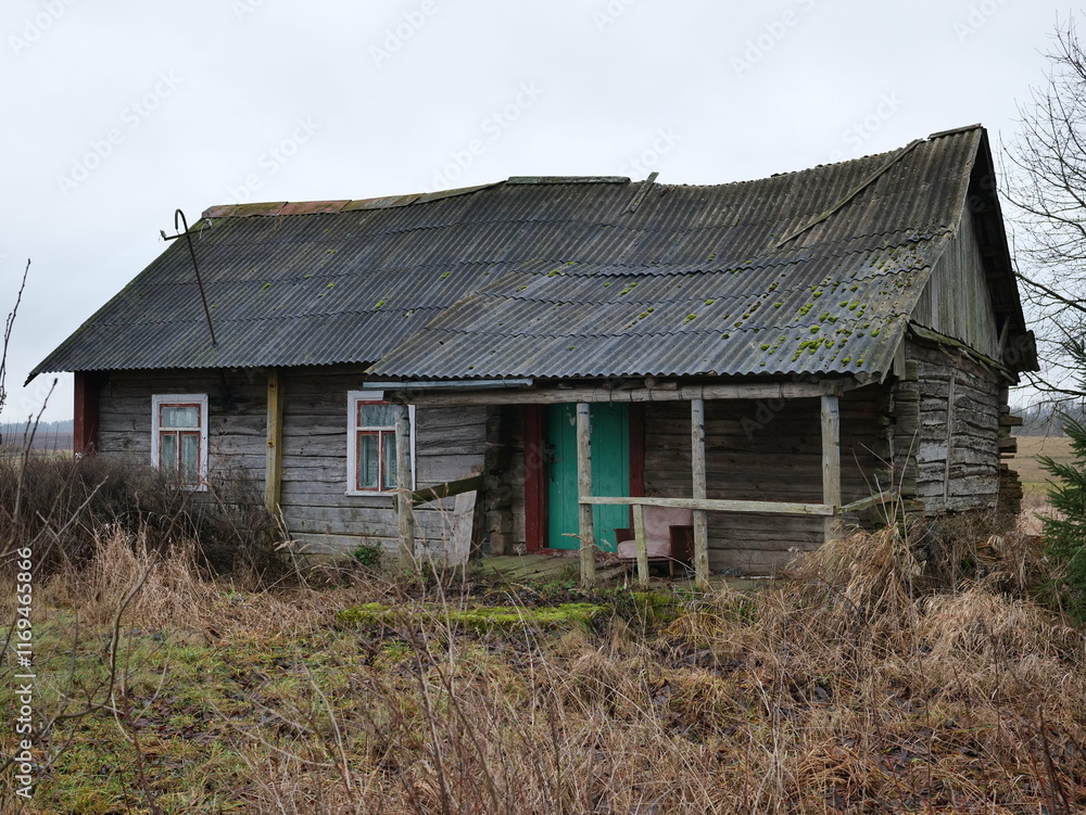 A dilapidated wooden house with a mossy roof stands in an overgrown landscape, evoking deep feelings of nostalgia