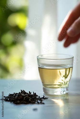 Refreshing beverage in a glass surrounded by tea leaves in a quiet outdoor se...