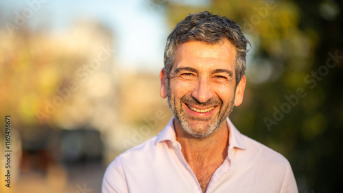 Принти на полотні Smiling man outdoors in warm sunlight with blurred background