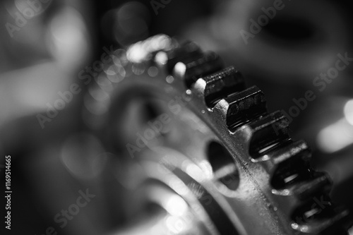 Black and white close-up of metal gears and mechanical parts symbolizing industrial equipment, precision engineering and mechanical processes, selective focus