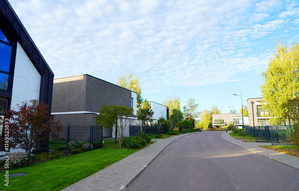 Obraz premium Modern luxury Villa. Street Road in Contemporary Residence. Modern Prefab house. Home with lawn, shrubs, green courtyard in sustainable enviroment. Family House in Gated Community. Landscaping at home