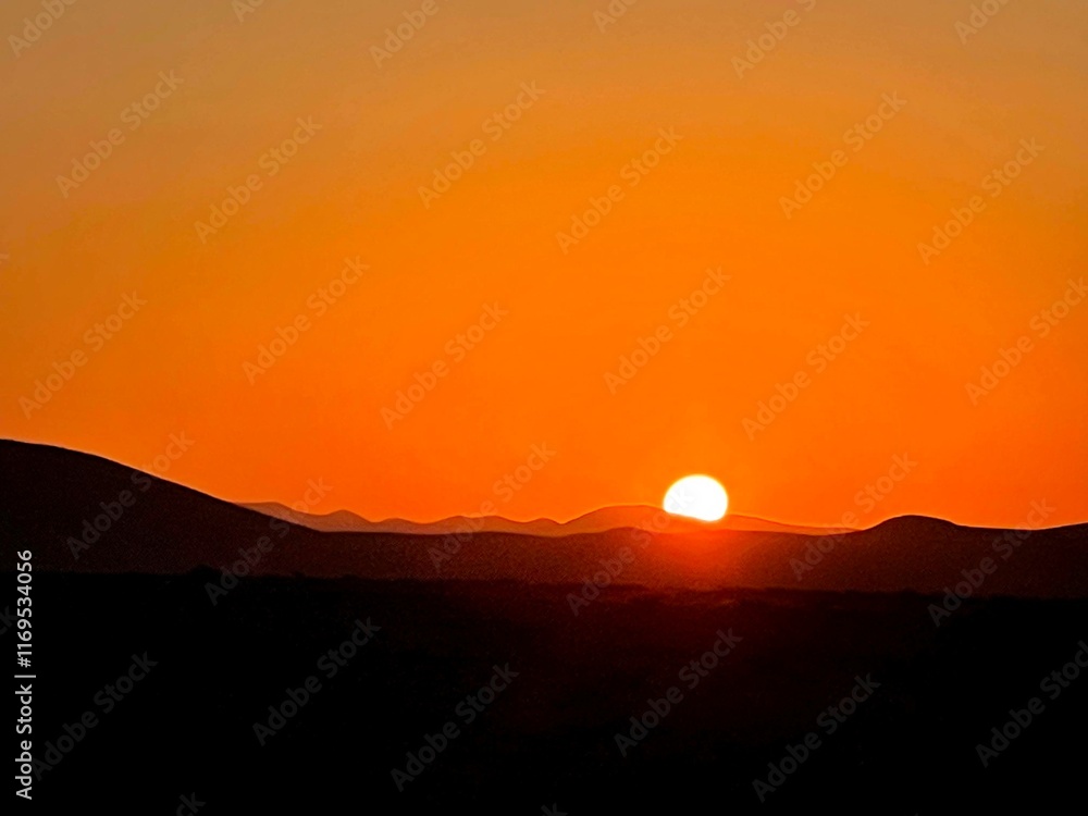 Fototapeta premium Golden Sunrise Over Desert Horizon