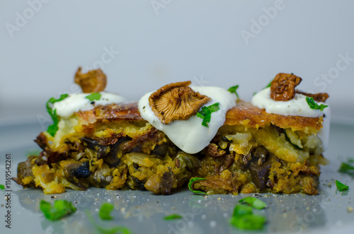 Potato cake with mushrooms with sour cream and herbs in the grey plate, top view photo