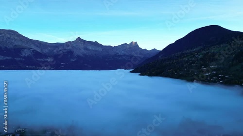 Wallpaper Mural Aerial view of Saint-Gervais-les-Bains in the French Alps near Chamonix at dawn, covered in a thick layer of fog, revealing only rooftops and mountain peaks. A serene and mystical alpine landscape. Torontodigital.ca